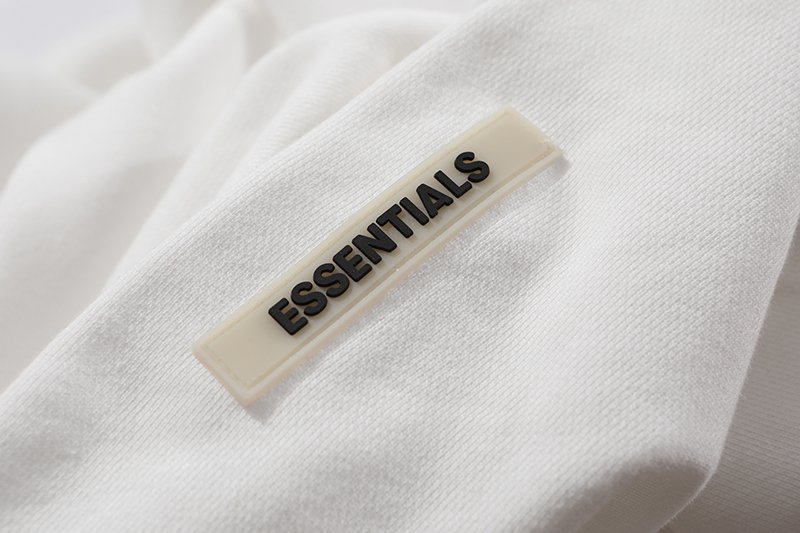 White T-shirt with "ESSENTIALS" label, popular K-pop merchandise item.