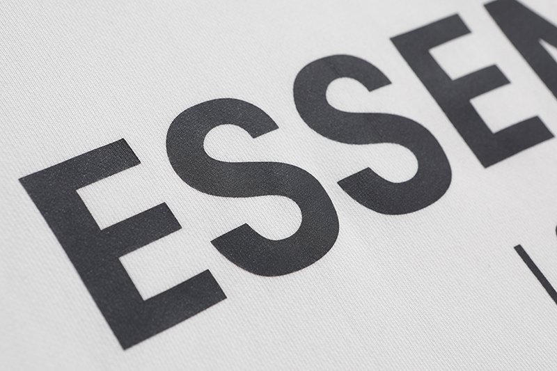 Black and white text reading "ESSENTIALS" with a close-up focus.