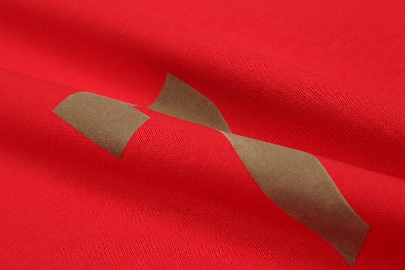 Kpop merch, twice merchandise, vibrant red fabric with gray tape, close-up of textured red material with partial gray tape, colorful and trendy K-pop merchandise item designed for fans of Twice.