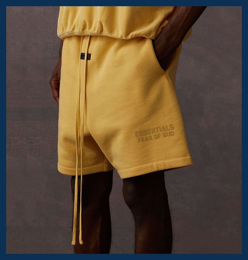 Yellow sweatshirt and shorts set, K-pop merchandise, fashion, casual, streetwear, stylish outfit for fans, popular in the K-pop community, comfortable and trendy, logo detail "ESSENTIALS FEAR OF GOD".