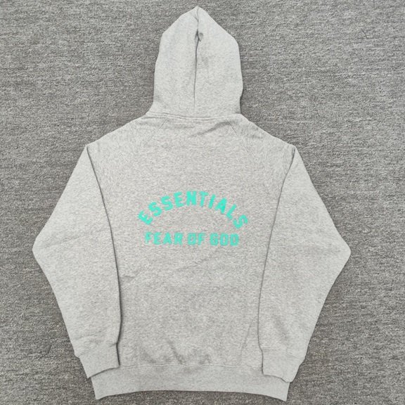 Hoodie with "ESSENTIALS FEAR OF GOD" text in turquoise, casual streetwear style perfect for K-pop fans and fashion enthusiasts.