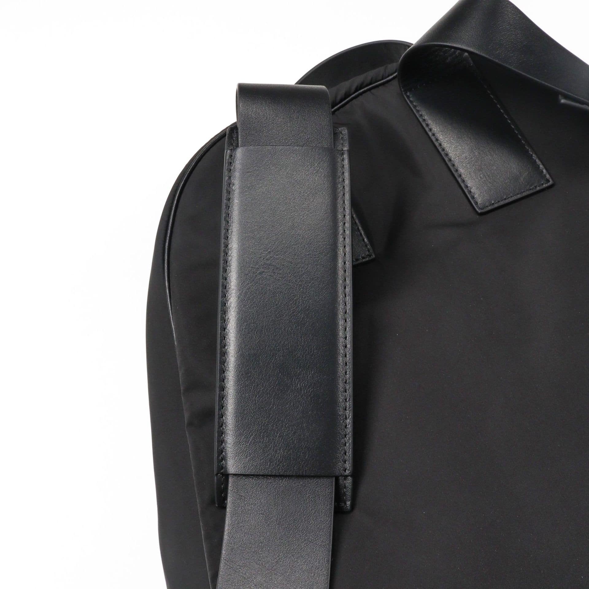 Black leather backpack with thick shoulder straps for K-pop merchandise fans.