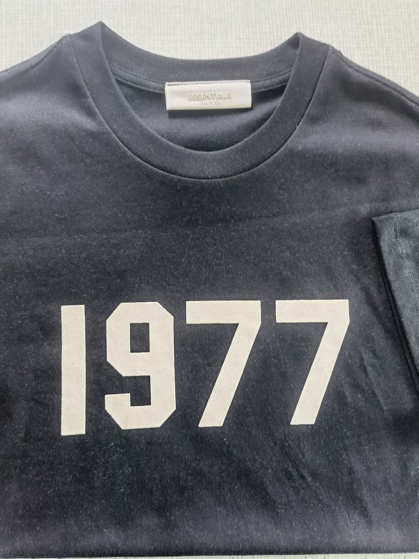 Black kpop merch sweatshirt with bold white "1977" print for fans of K-pop music. Perfect for casual wear or concerts, represents fandom or a specific year significance. Made from comfortable fabric.
