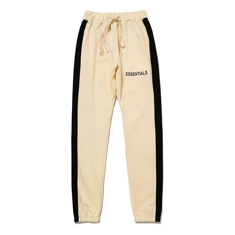 Comfy beige joggers with black side stripes and "ESSENTIALS" logo, perfect for casual kpop style.