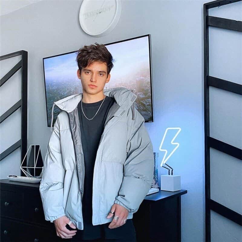 Hyejin in her room with kpop merch on display and neon lightning decor behind her.