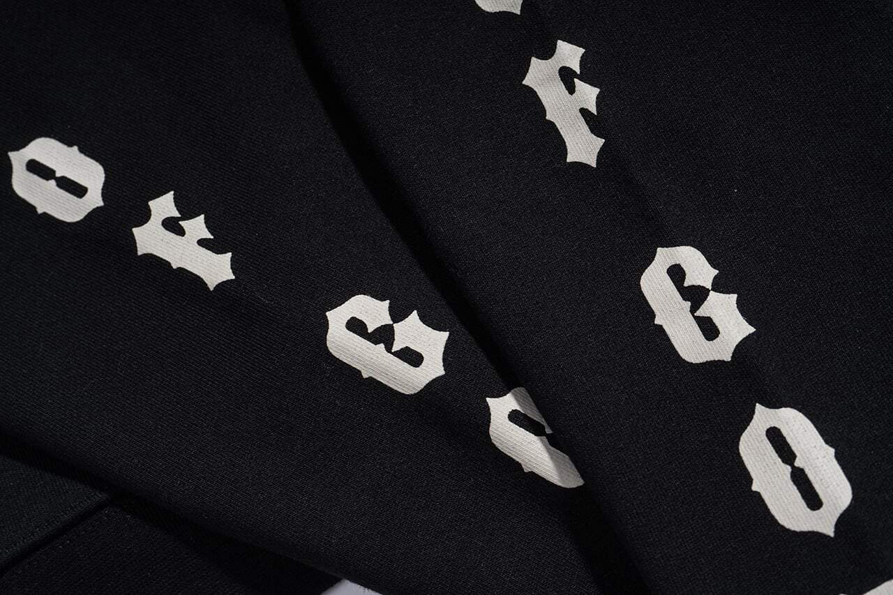 Black fabric with white "B" and holly leaf patterns, popular K-pop merchandise style.