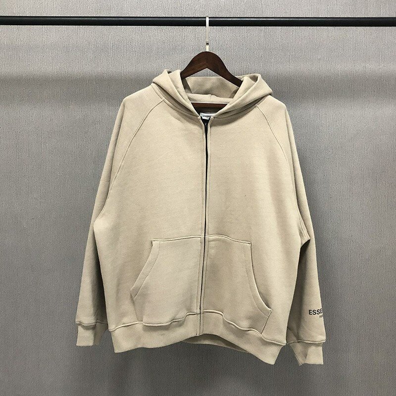 Beige oversized hoodie with front zipper and kangaroo pocket, casual streetwear style, plain design with small logo on sleeve, suitable for everyday wear.