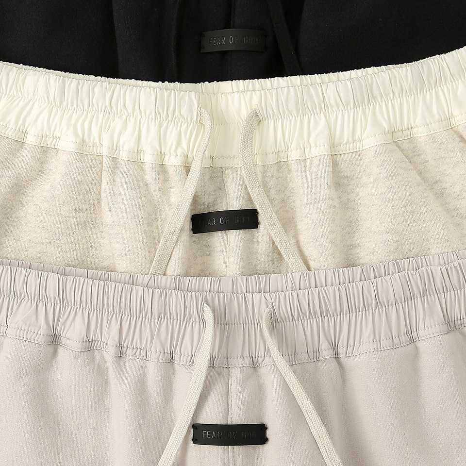 Shorts with "Fear of God" label and drawstrings, available in light beige and white, trending K-pop merchandise.