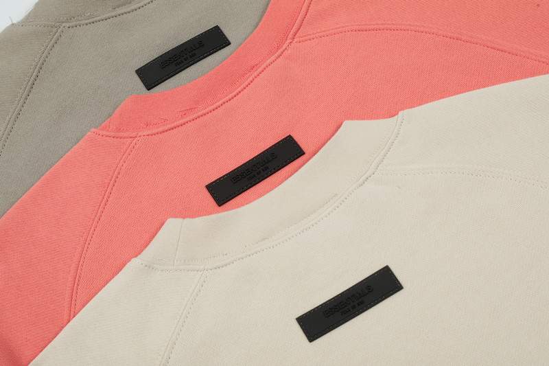 Fuzzy pink, beige, and white kpop merchandise t-shirts layered with black brand labels, perfect for fans of twice kpop merch.
